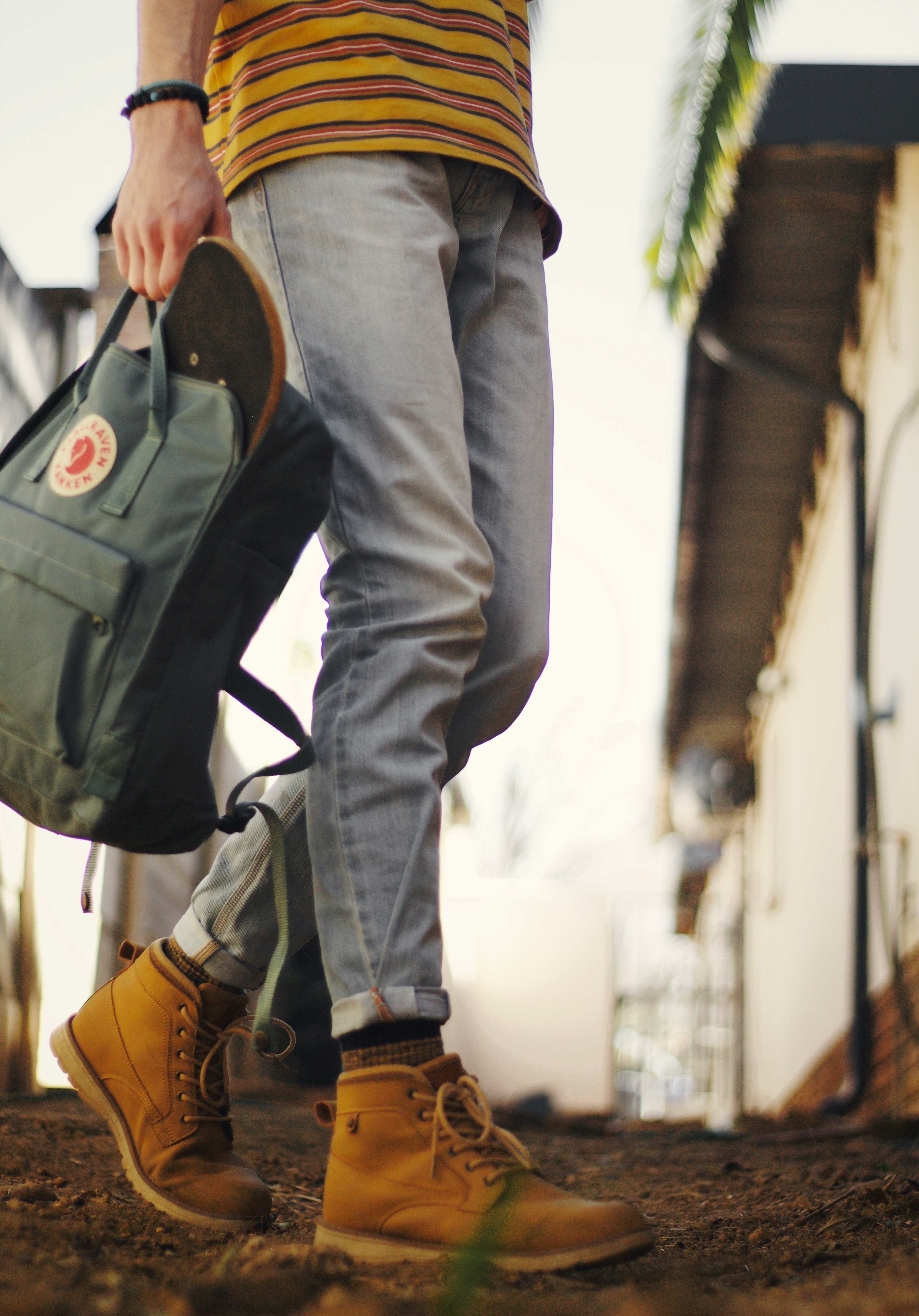 person in blue denim jeans and brown leather boots